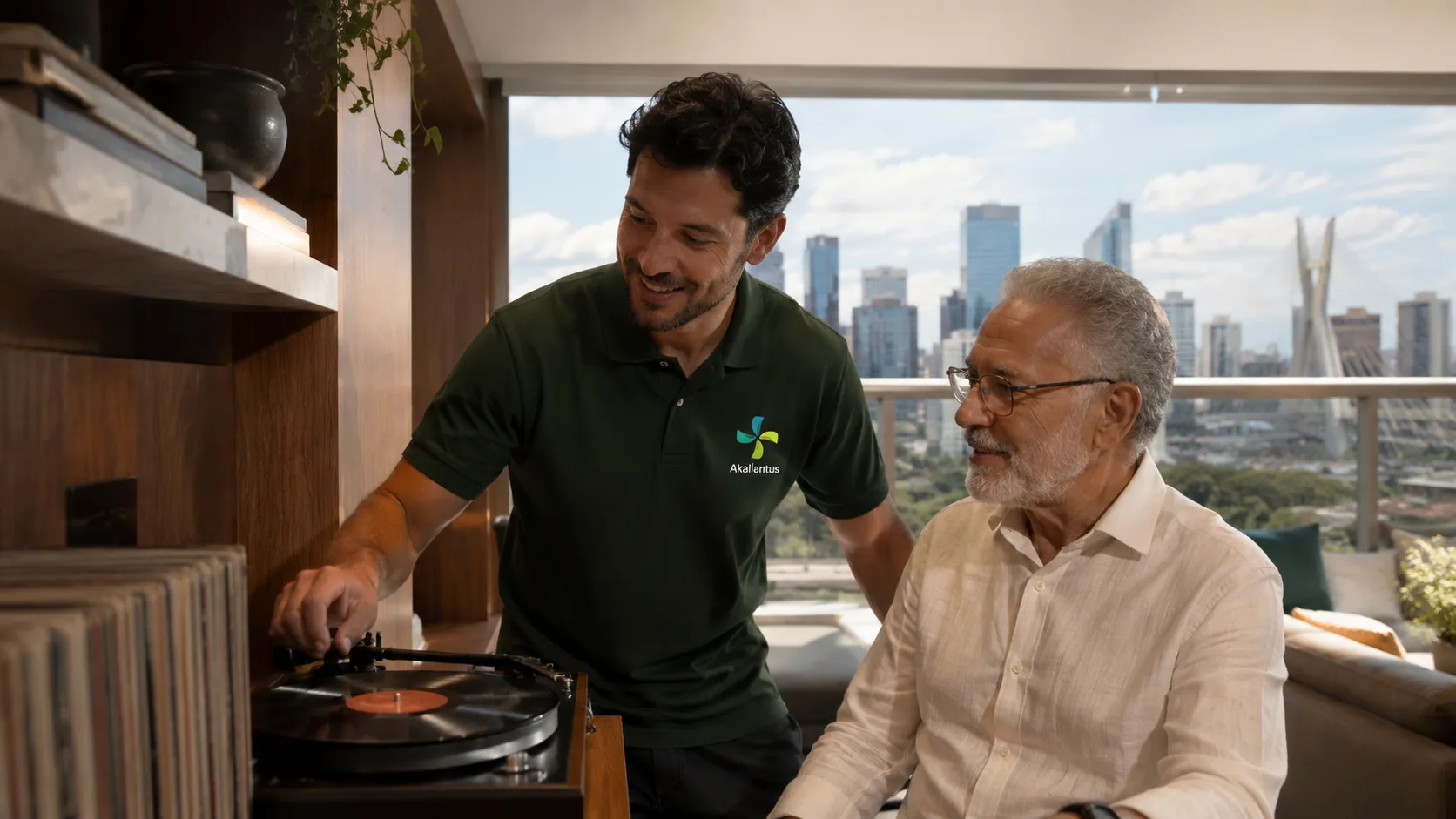 Cuidador da Akallantus ajuda um senhor idoso a ouvir um disco de vinil em um apartamento no Brooklin, São Paulo, com o skyline e a Ponte Estaiada ao fundo.