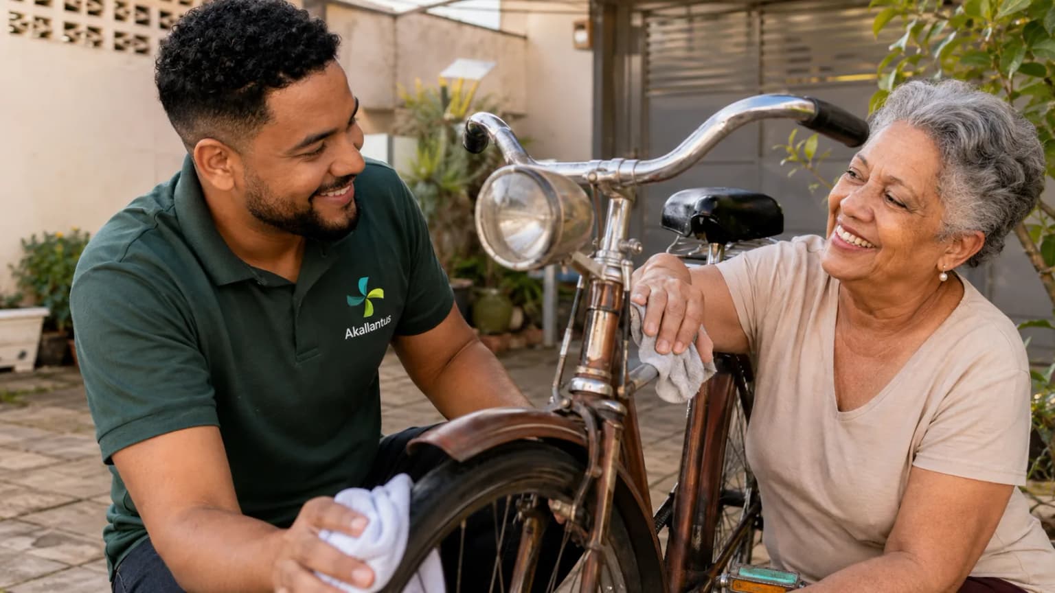 Cuidador da Akallantus ajuda uma senhora idosa a limpar uma bicicleta antiga no quintal de casa, em São Bernardo do Campo.